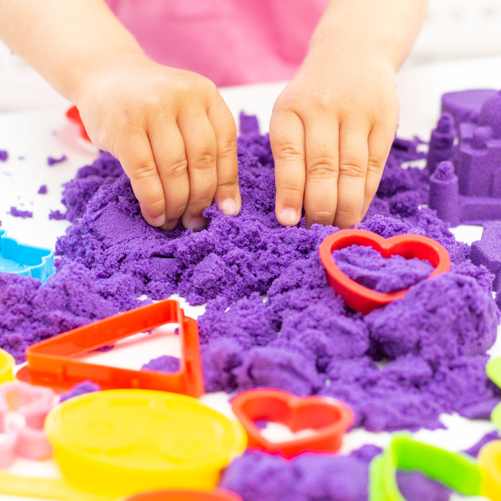 a child playing with purple sand