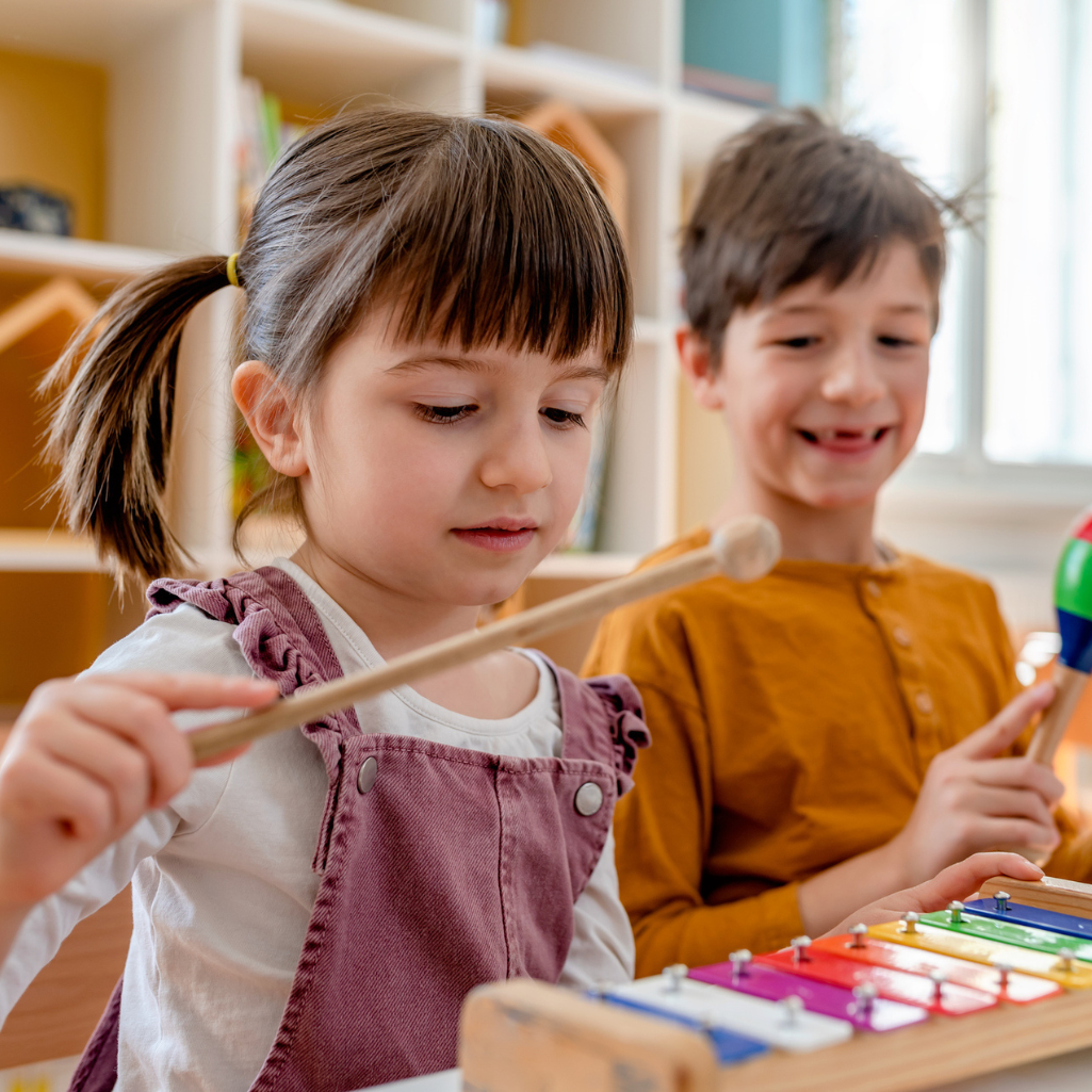a boy and girl playing with xylophones