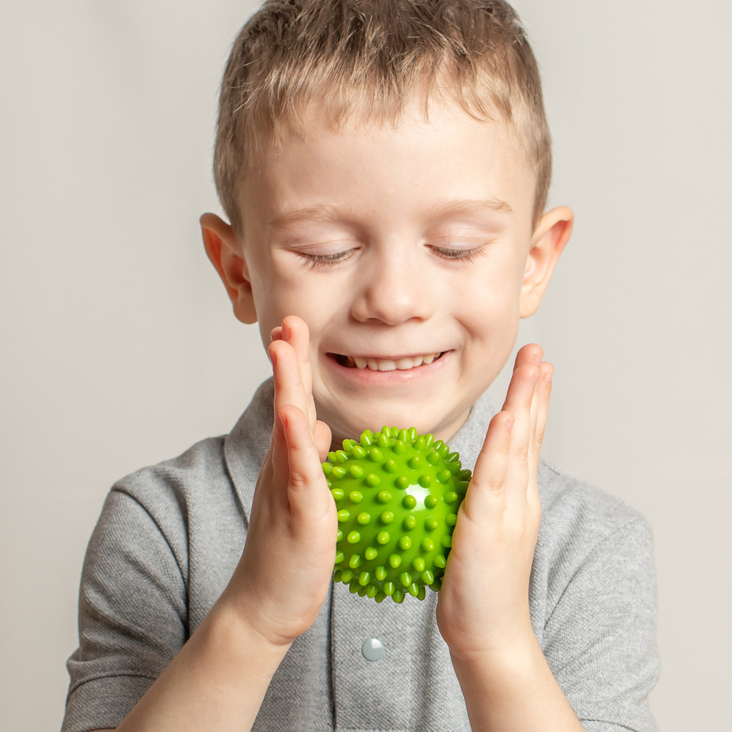 a boy holding a green ball